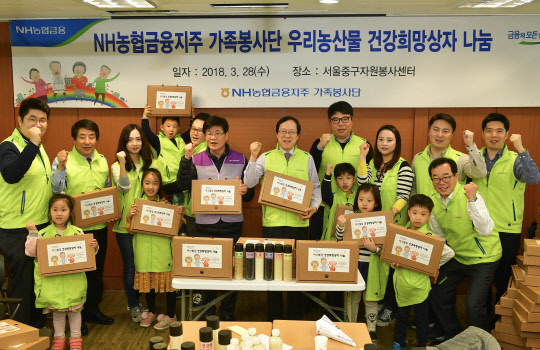 28일 서울 중구자원봉사센터에서 진행된 '우리농산물 건강희망상자 나눔 봉사활동에서 김용환 농협금융지주 회장(뒷줄 왼쪽 다섯 번째)이 가족봉사단이 기념촬영을 하고 있다. NH농협금융지주 제공